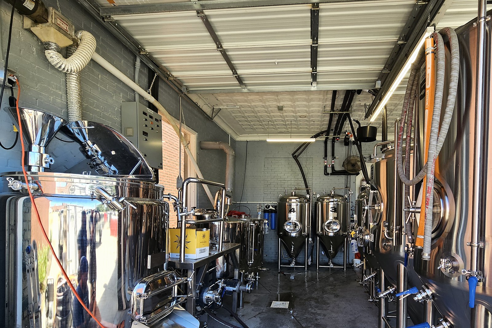 Installed brewhouse with mash tun, fermenters, and brite tanks in an operating brewery